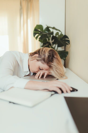 a woman with her head down resting on her arm