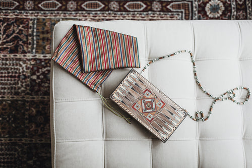a wooden bag with a beaded handle