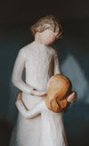 a wooden figurine of mother and child