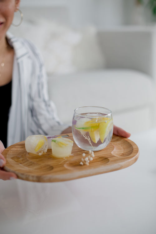 a wooden tray carries a cocktail glass