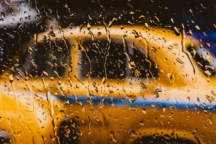 a-yellow-taxi-behind-a-rain-spattered-wi