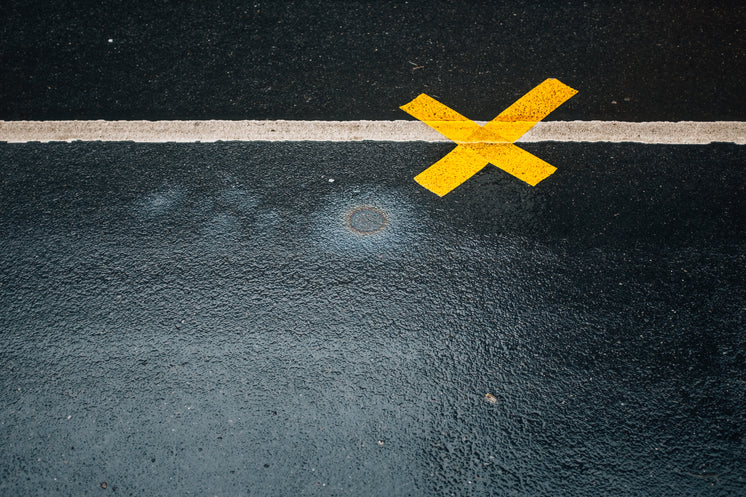 A Yellow X On Asphalt