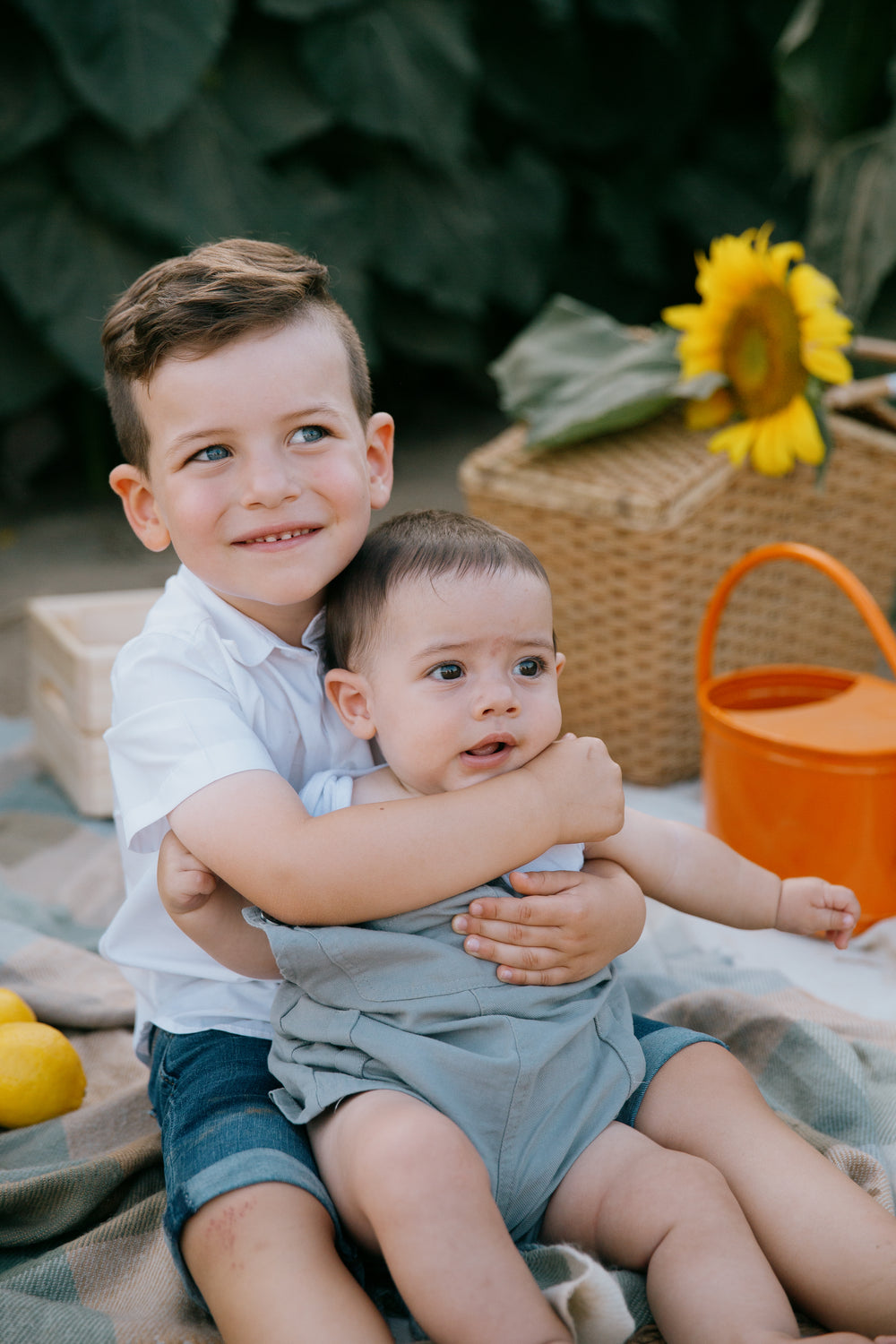 a young child holds a baby on their lap