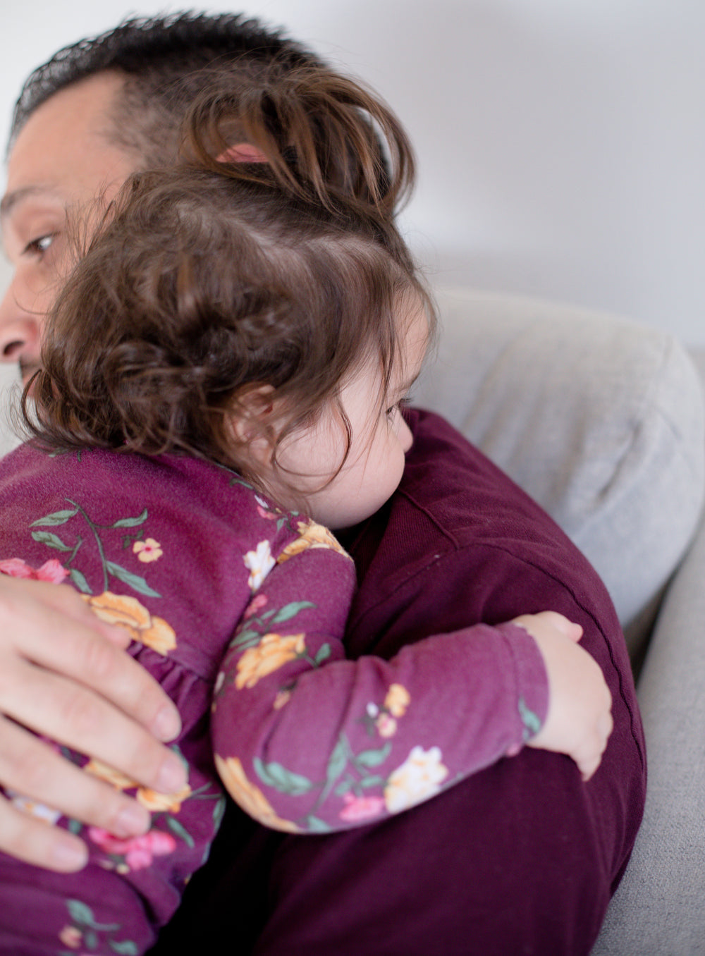 a young child is held in a someones arms