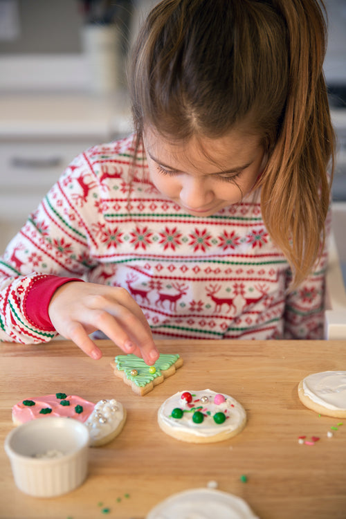 a young girl carefully decorated cookies