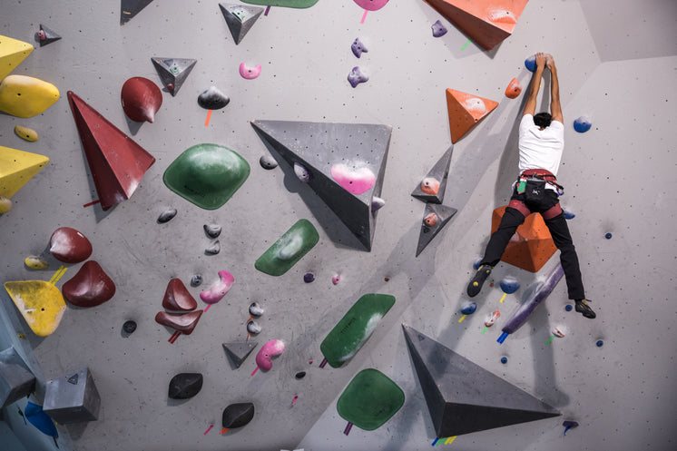 A Young Rock Climber Hangs From A Wall