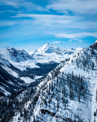 aerial image of snow covered mountains under bright sky