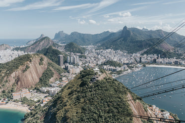 aerial photo of a waterfront city in tall green mountains