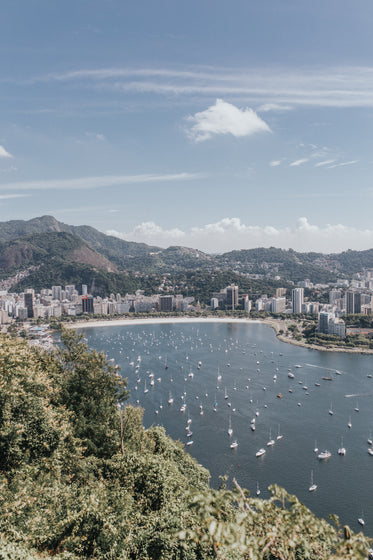 aerial photo of boats in water next to a city coastline