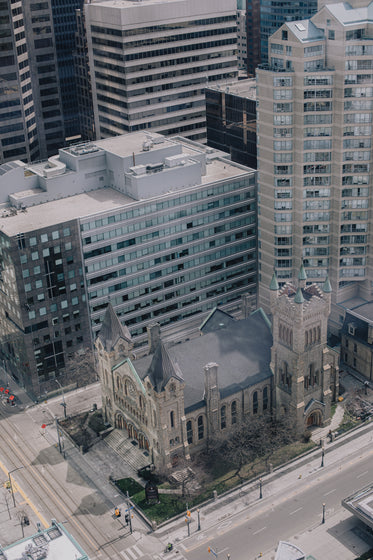 aerial view of a church with tall building surrounding it