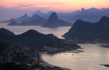 aerial view of a sunset behind mountains by the shore