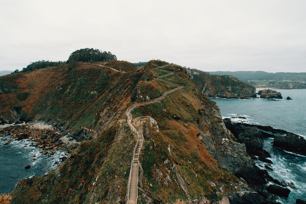 aerial view of a walkway through rocky hills by the water