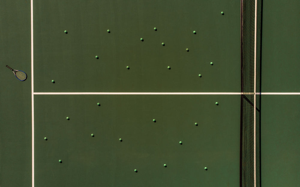 aerial view of tennis balls and a racket on the court