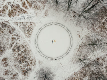 aerial view of two snow angels surrounded by trees