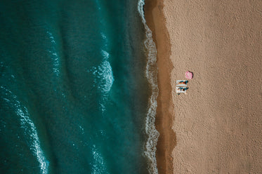 aerial view of two women sitting on sandy beach