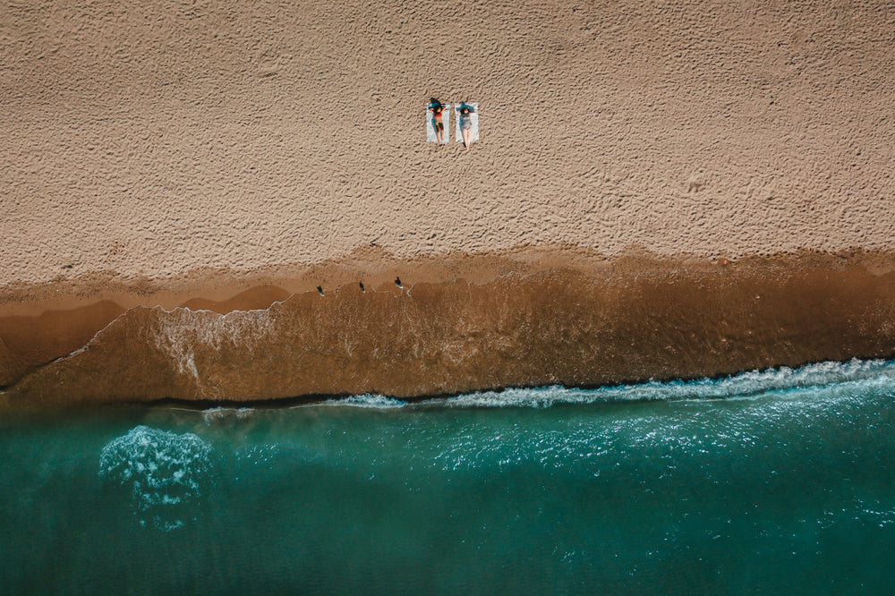 aerial view of waves washing up along sandy beach