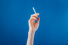 ahand holding a cigarette on blue background