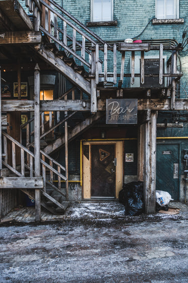 alley entrance to a bar with trash bags piled near the door