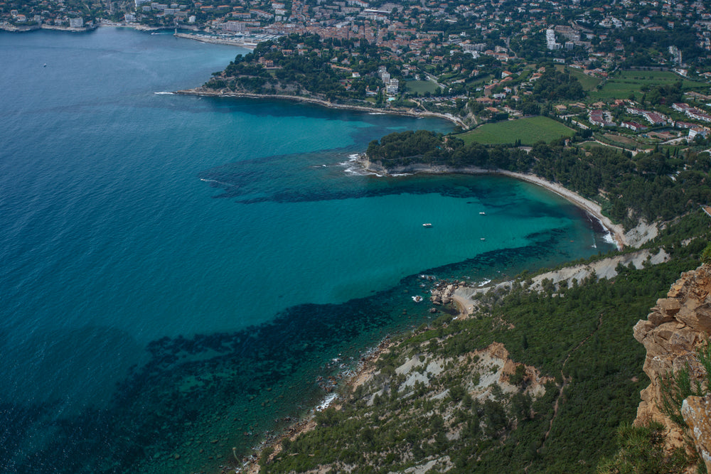 an aerial view of clear blue water by the shore