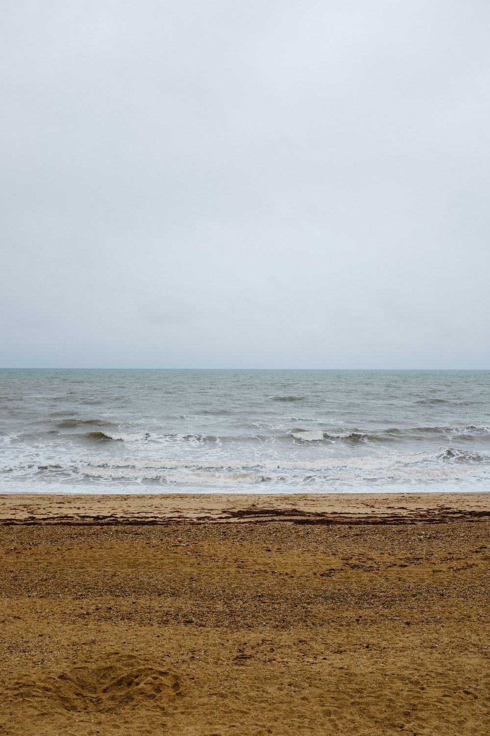 an empty beach under an overcast sky