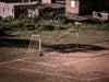 an empty sports net with green and brown grass