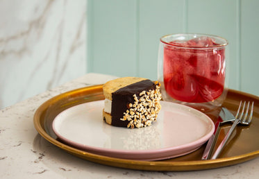 an ice cream sandwich and a glass of juice on a tray