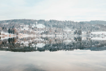 an icy lake under snowy and snowy hills under frosty sky