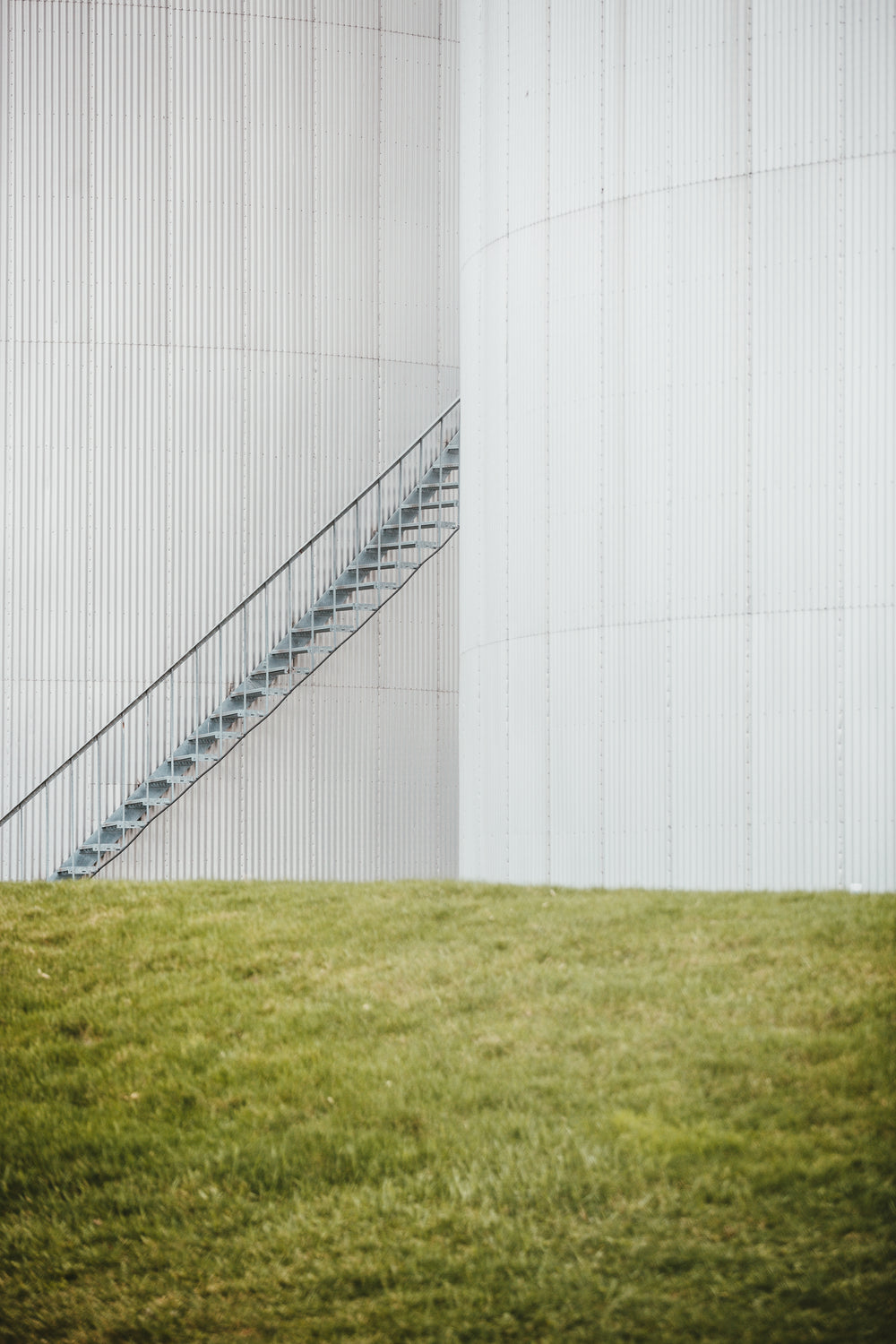 an iron staircase stretches from the grass up the building