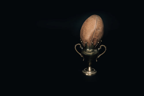 an old leather football and trophy
