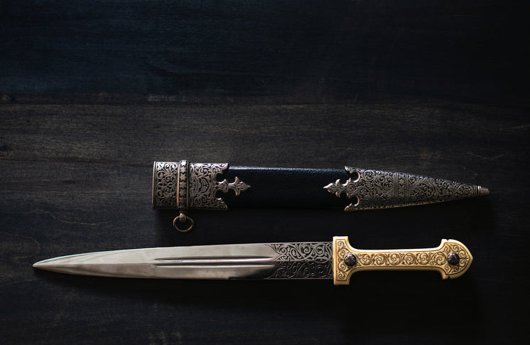 An Ornate Dagger And Sheath On A Wooden Table