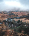 ancient railway bends beneath the foggy hillside