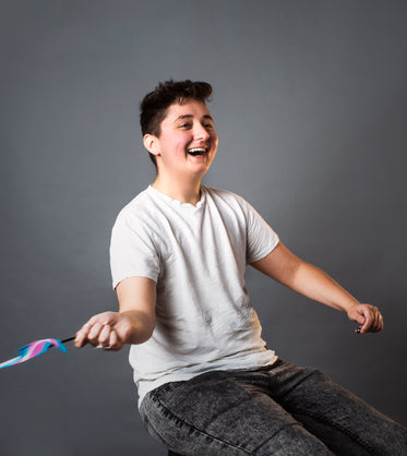 androgynous person waving trans pride flag portrait