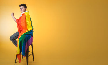 androgynous person wrapped in rainbow pride flag