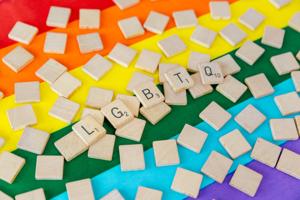 angled view lgbtq scrabble letters over pride flag