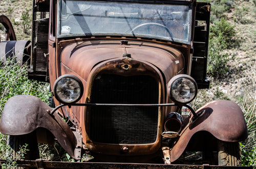 antique car in a scrap yard
