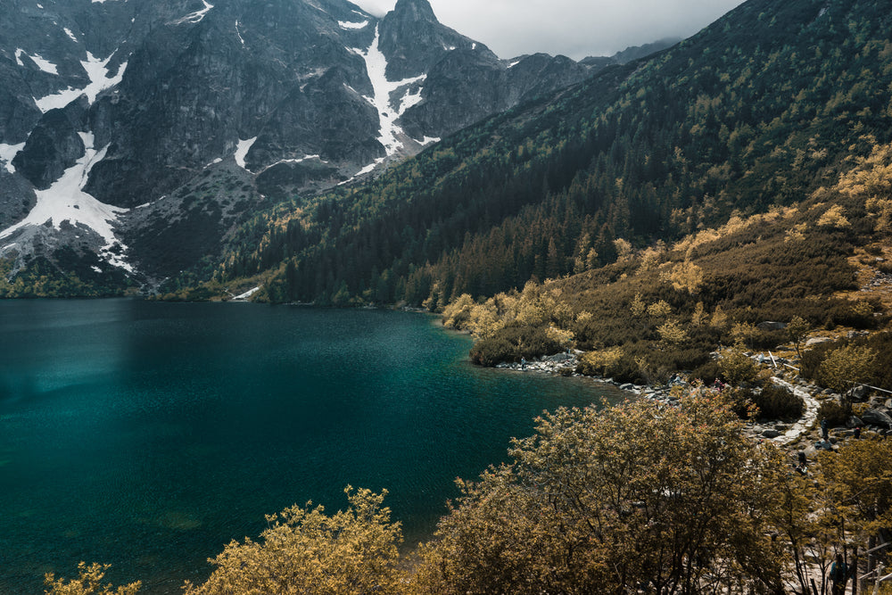 aqua blue water surrounded by mountains and trees