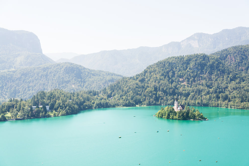 aqua blue water surrounded by tall green hilly trees