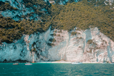 aqua blue water with boats and white cliffs