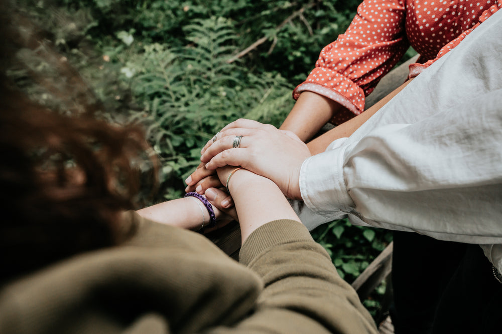 arms reach into pile hands on top of each other