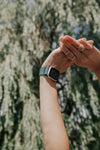 arms reach up with a smart watch on