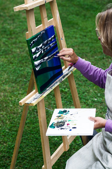 artist adds white to their painting of birch trees