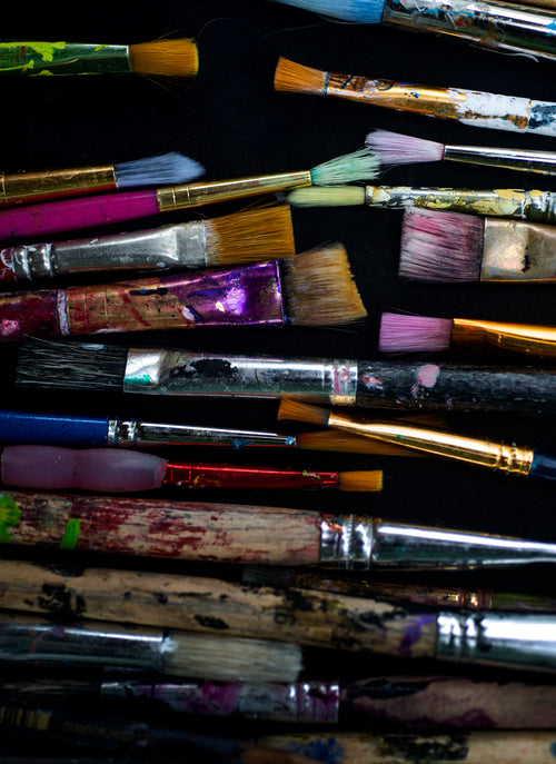 artist paint brushes on a black surface