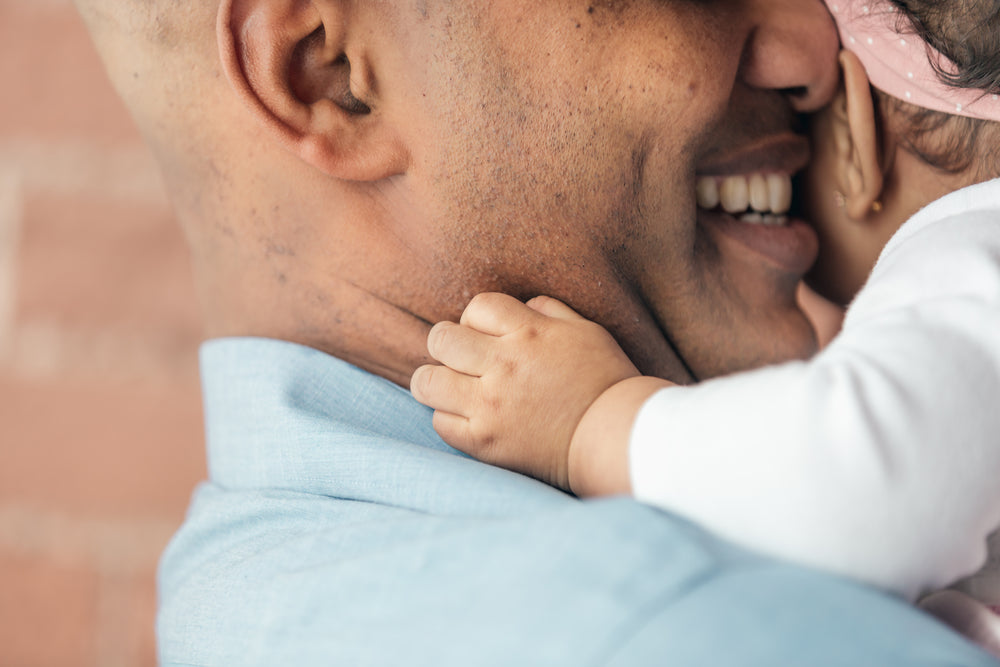 baby girls hands hugging father