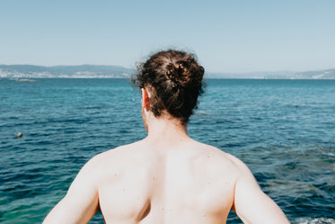 back of a person looking out to the choppy ocean