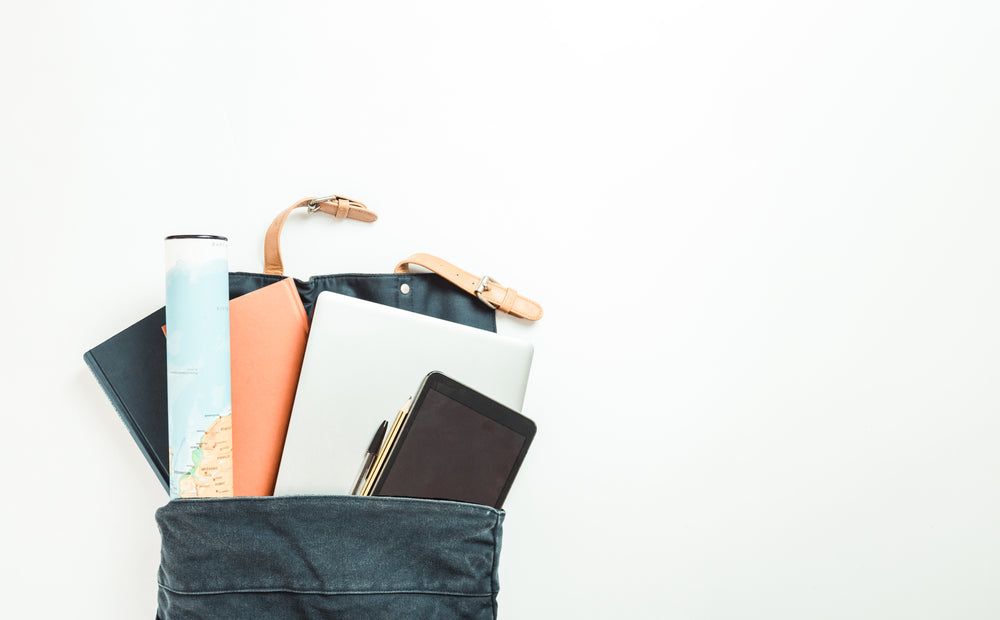 backpack with books a map and tech falling out of it