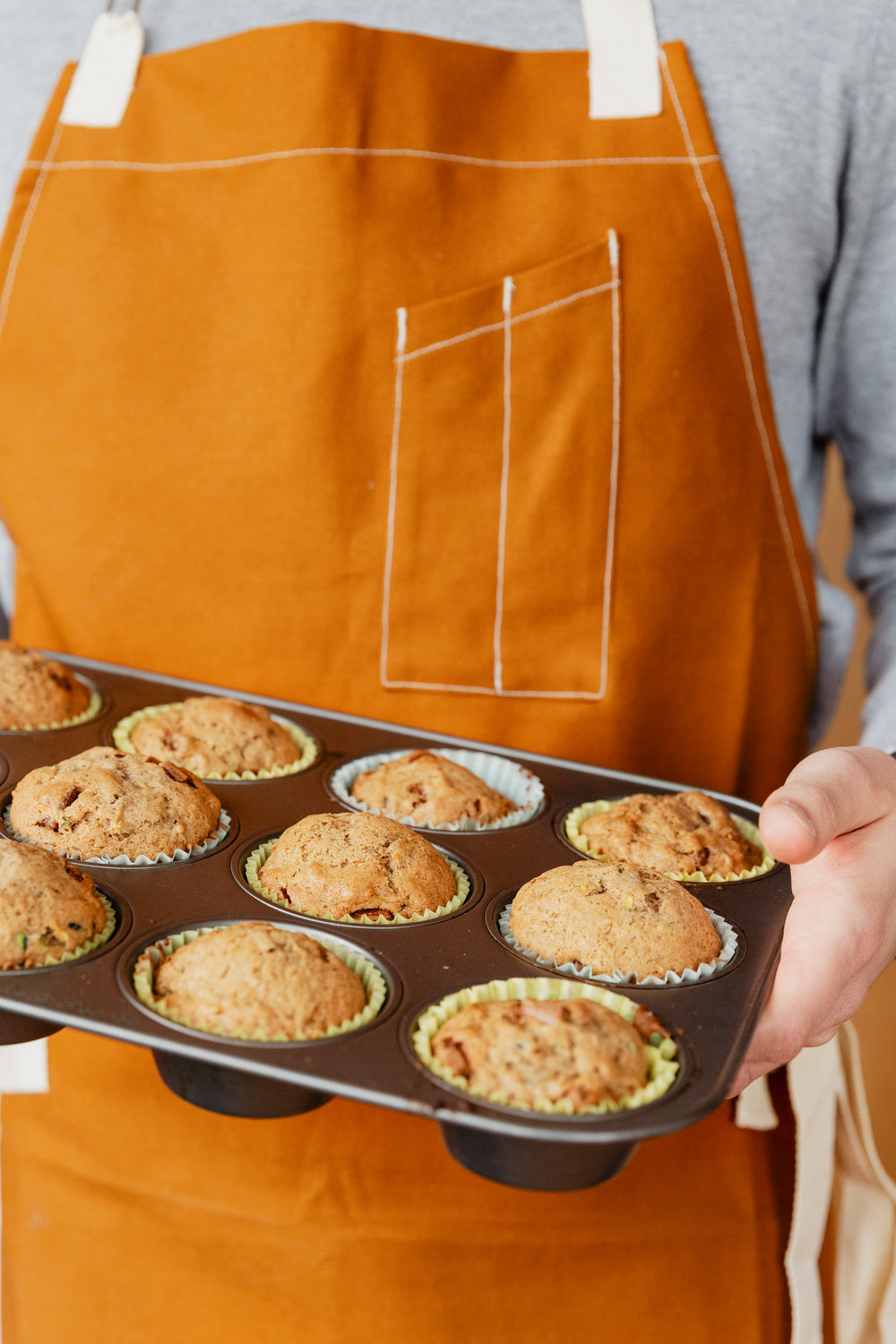 baker holding fresh muffins