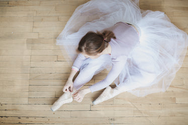 ballet dancer ties up slippers