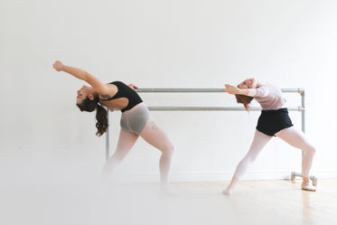 ballet dancers warm up at bar