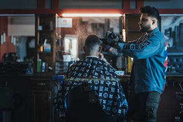 barber sprays water on customers head