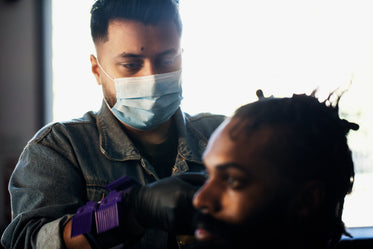 barber wears a face mask while cutting hair